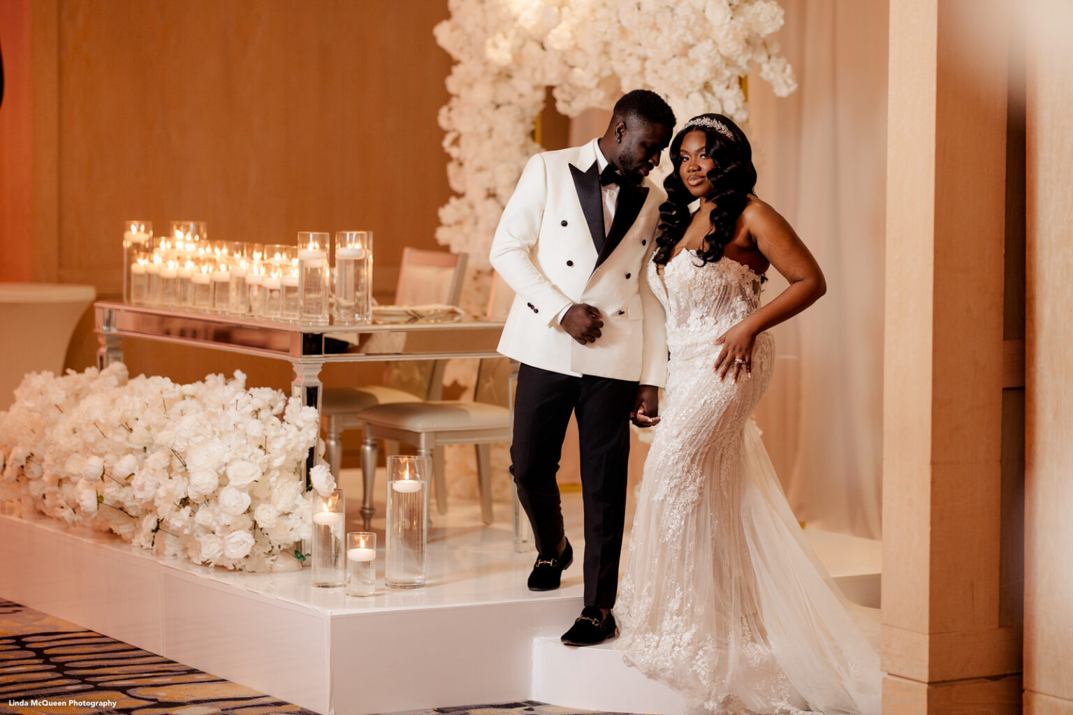 bride and groom pose by the sweetheart table